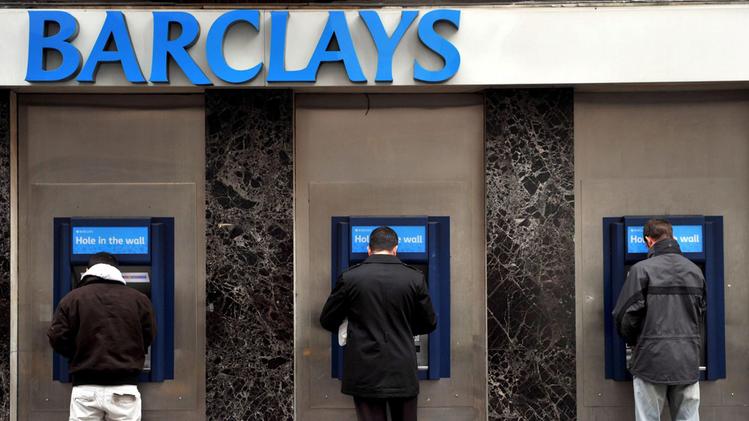 Risparmiatori mentre prelevano da uno sportello Barclays